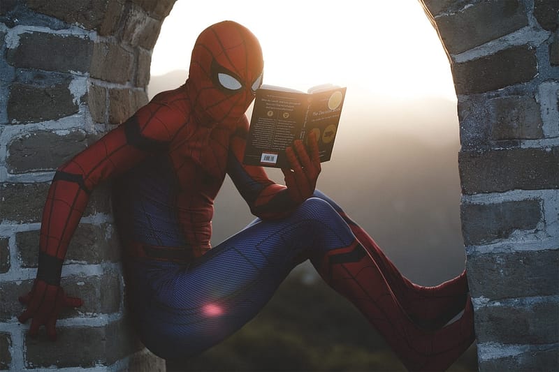 Spider-Man reading a book.